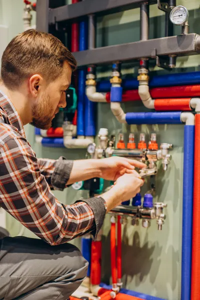 man tightening a pipe